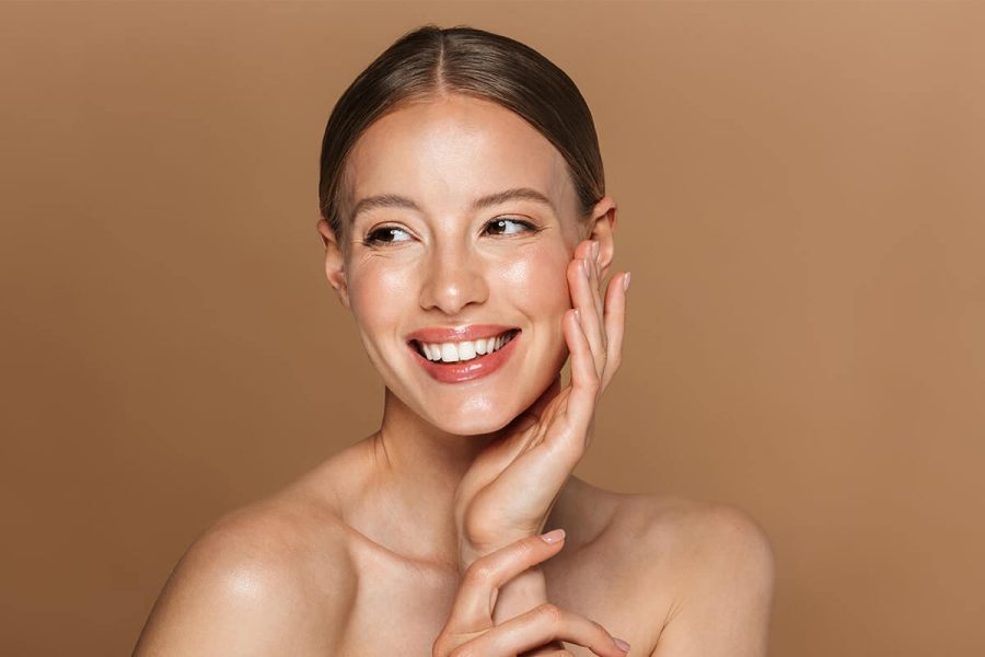 Mulher com aparência de ter uns 30 anos feliz pelos benefícios da vitamina E na pele
