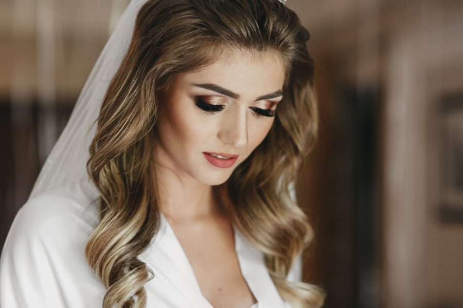 Mulher vestida de noiva maquiada com lápis preto e máscara de cílios