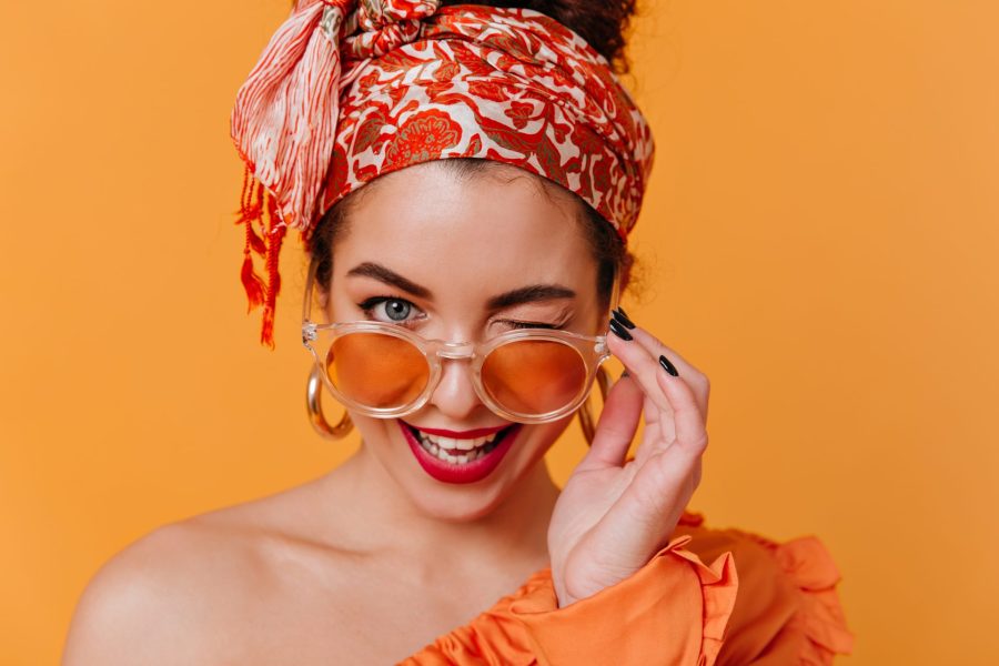 Mulher com roupa de calor, bem descolada, usando óculos e piscando